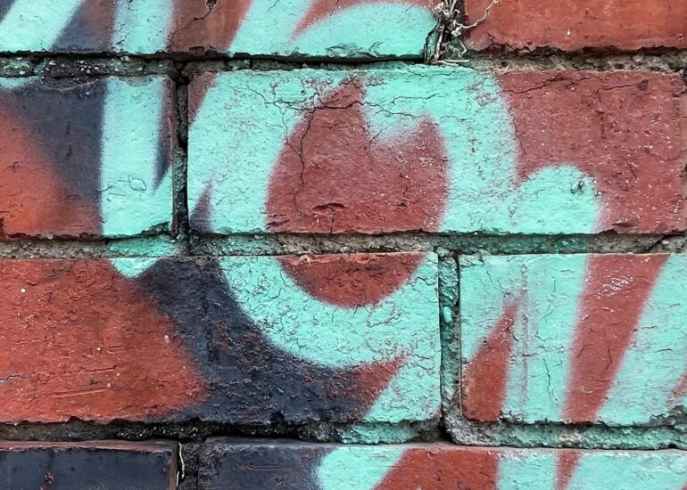 Pale teal spray-painted numerals over weathered red brick, Melbourne inner north, hidden__north documentary photography