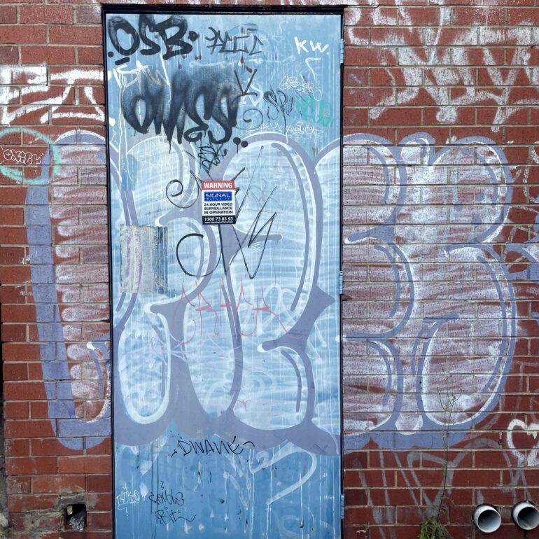 Blue tagged door, red brick laneway, Melbourne inner north, hidden__north documentary photography