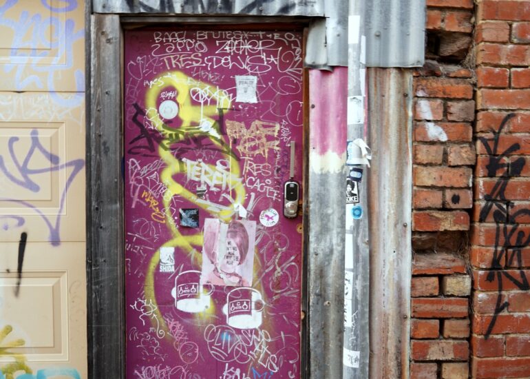 Magenta door with graffiti scrawl, laneway, Melbourne inner north, hidden__north documentary photography