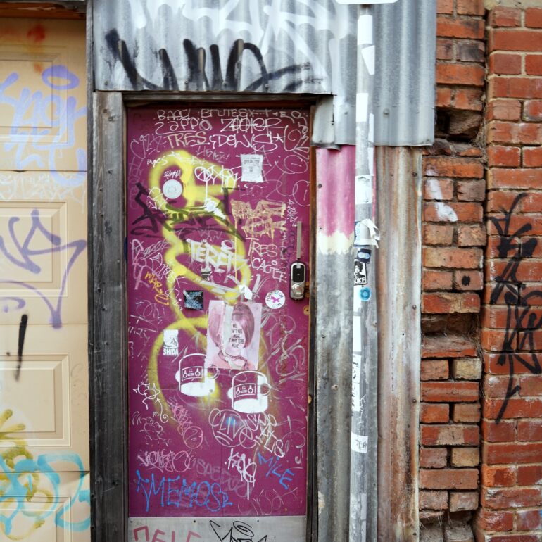 Magenta door with graffiti scrawl, laneway, Melbourne inner north, hidden__north documentary photography