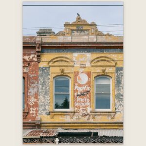 Ochre Victorian facade with arched windows and a Pacific Photo Service ghost sign, Carlton North, Melbourne inner north, hidden__north documentary photography