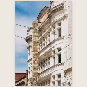 Vertical Patersons sign on a white ornate facade cut by overhead wires, Collingwood, Melbourne inner north, hidden__north documentary photography