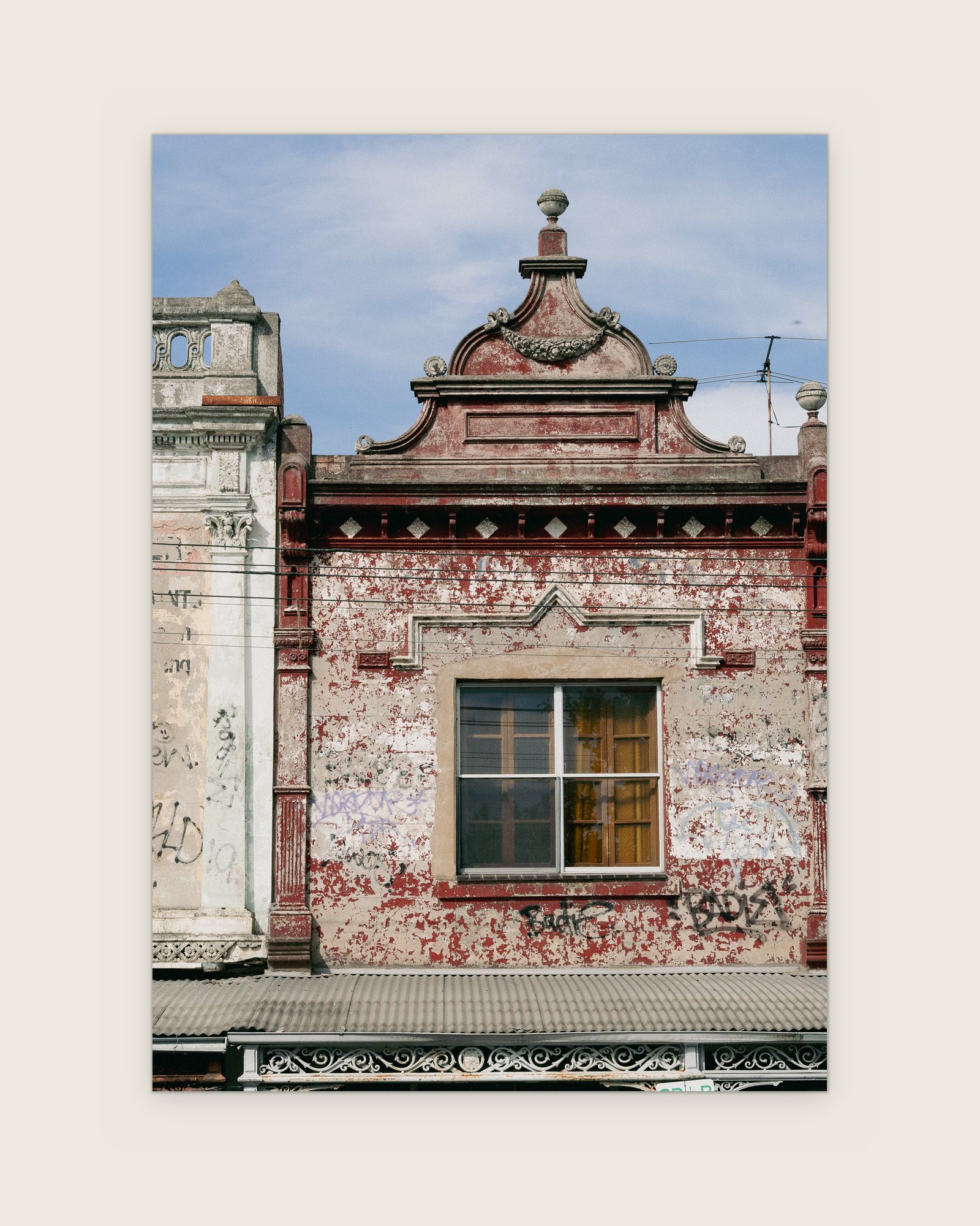 Weathered red and white Victorian shopfront pediment, Carlton North, Melbourne inner north, hidden__north documentary photography