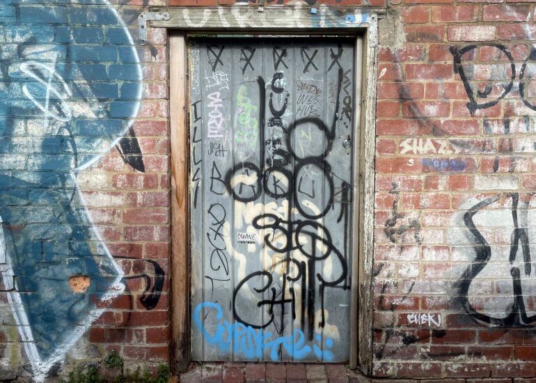 Tagged door, brick wall mural, Melbourne inner north, hidden__north documentary photography