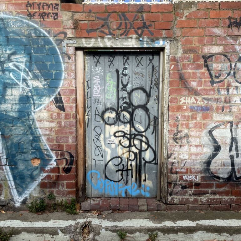 Tagged door, brick wall mural, Melbourne inner north, hidden__north documentary photography