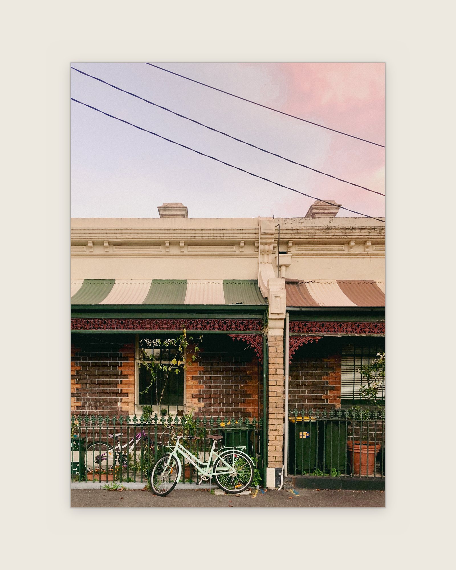 Victorian terraces with striped verandah awnings and a bicycle against the iron lace, Carlton, Melbourne inner north, hidden__north documentary photography