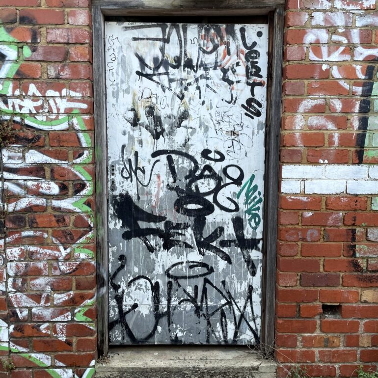 White tagged door, brick archway, Melbourne inner north, hidden__north documentary photography