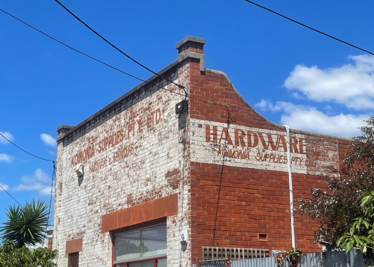 Faded Koinonia Supplies Hardware ghost sign on a whitewashed brick warehouse, Melbourne inner north, hidden__north documentary photography