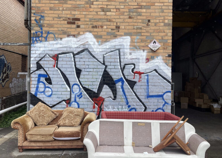 Two couches left against a graffiti wall, Melbourne inner north, hidden__north documentary photography