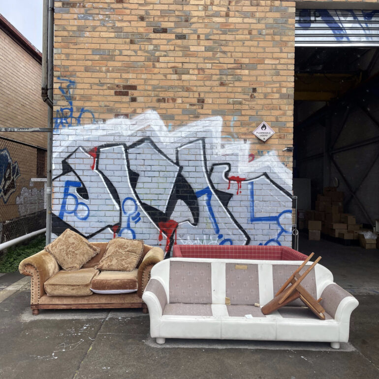 Two couches left against a graffiti wall, Melbourne inner north, hidden__north documentary photography
