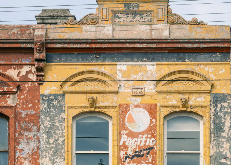 Ochre Victorian parapet with faded Pacific Photo Service sign, Melbourne inner north, hidden__north documentary photography