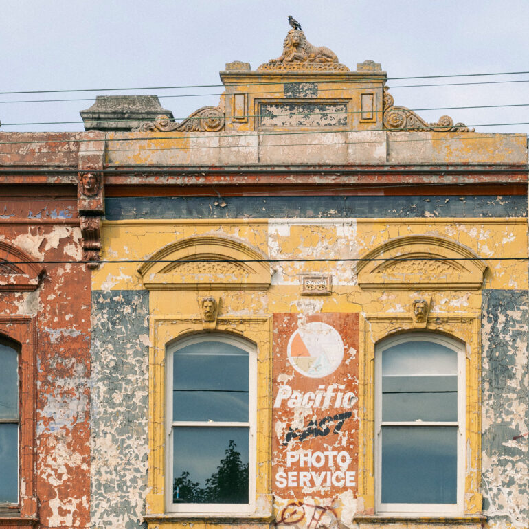 Ochre Victorian parapet with faded Pacific Photo Service sign, Melbourne inner north, hidden__north documentary photography