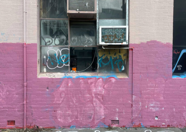 Half-painted pink wall below a tagged window, Melbourne inner north, hidden__north documentary photography