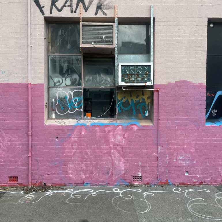 Half-painted pink wall below a tagged window, Melbourne inner north, hidden__north documentary photography