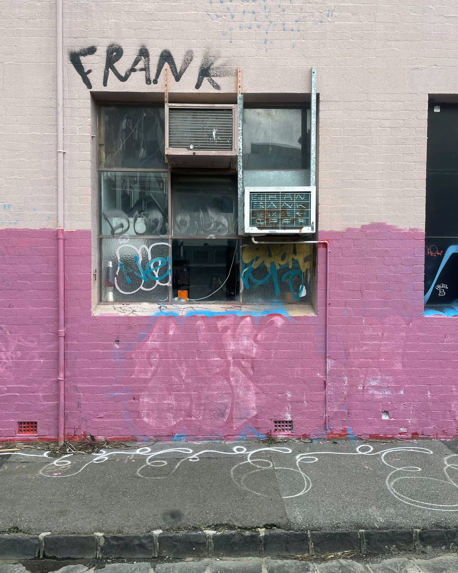 Half-painted pink wall below a tagged window, Melbourne inner north, hidden__north documentary photography