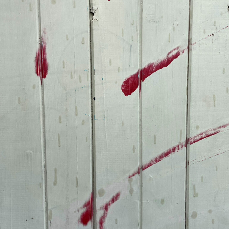 Red paint strokes on white weatherboard, Melbourne inner north, hidden__north documentary photography