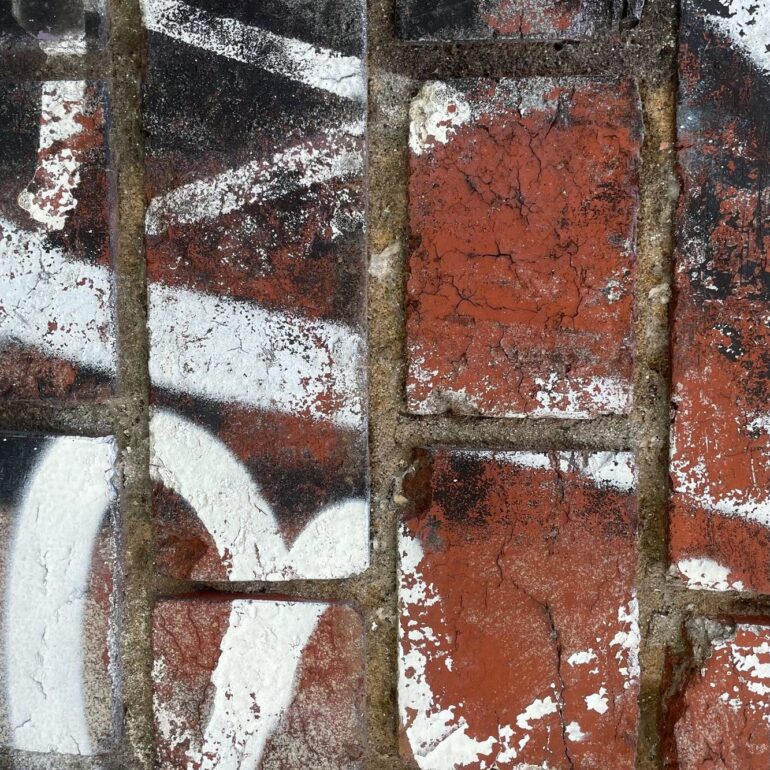 White painted marks over a rusted grille and brick, Melbourne inner north, hidden__north documentary photography
