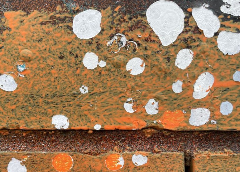 White paint splatter over orange rust and brick, Melbourne inner north, hidden__north documentary photography