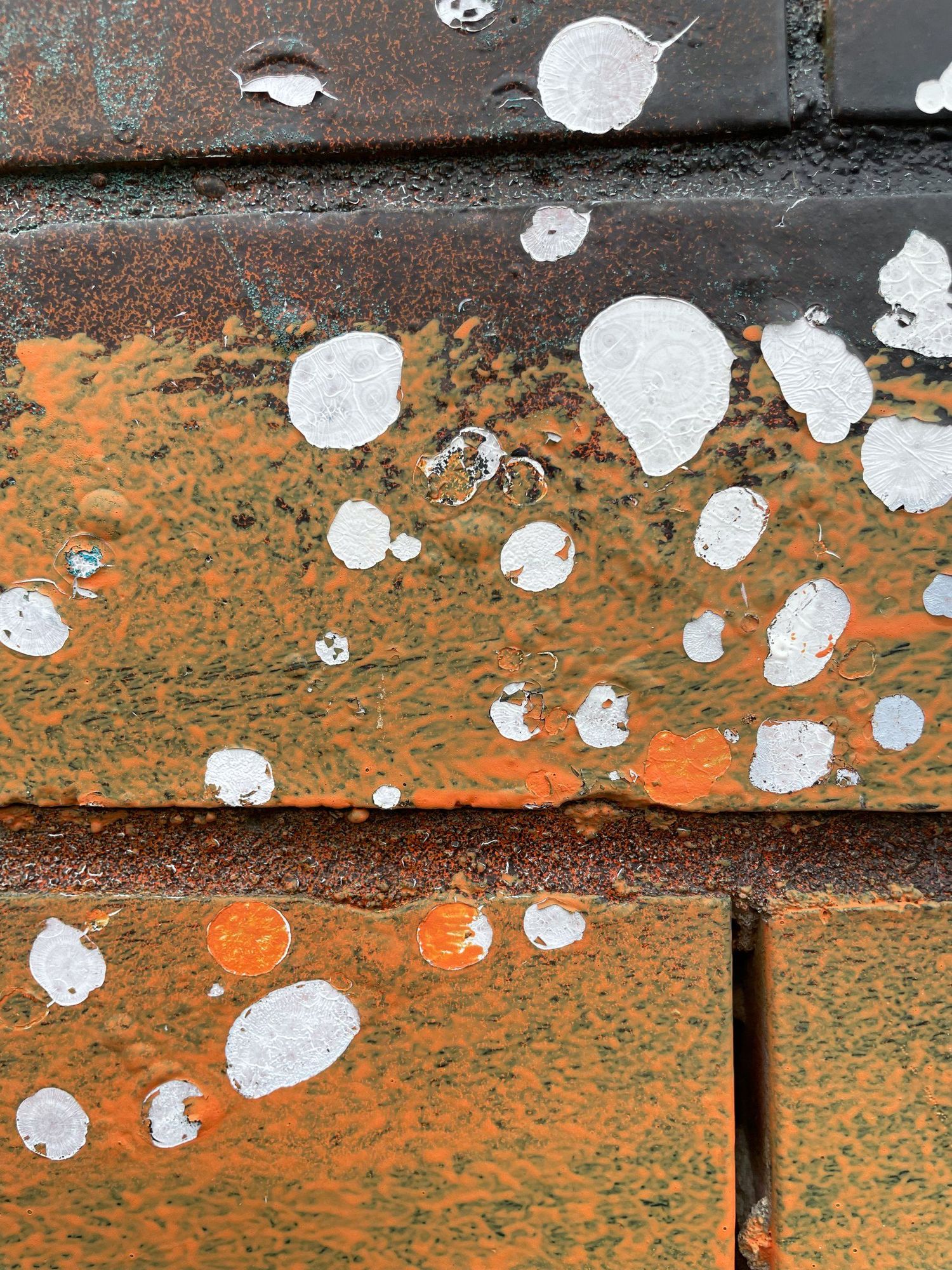 White paint splatter over orange rust and brick, Melbourne inner north, hidden__north documentary photography