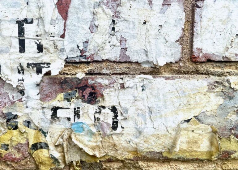 Torn paper posters layered on a brick wall, Melbourne inner north, hidden__north documentary photography