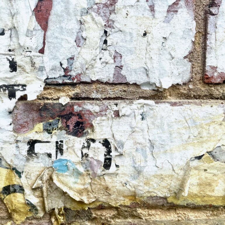 Torn paper posters layered on a brick wall, Melbourne inner north, hidden__north documentary photography