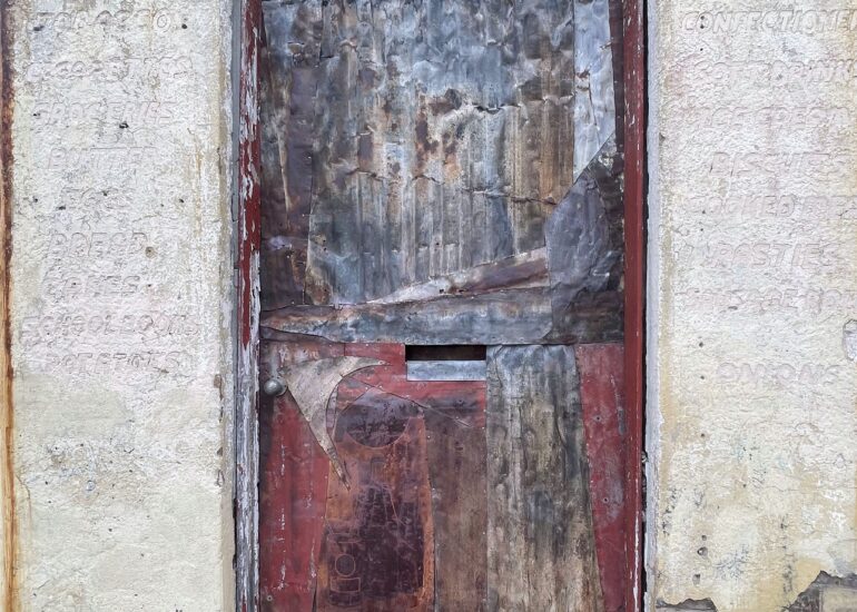 Boarded shopfront door with layered peeling paint and render, Melbourne inner north, hidden__north documentary photography