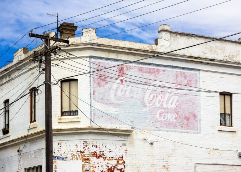 Faded Coca-Cola ghost sign on a white rendered corner building, Whitby Street, Melbourne inner north, hidden__north documentary photography