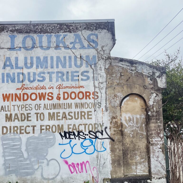 Faded Loukas Aluminium Industries ghost sign on a whitewashed wall, Melbourne inner north, hidden__north documentary photography