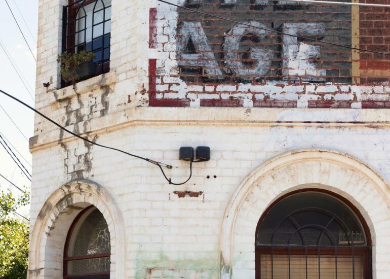 Faded The Age and Tarax ghost signs on a white painted corner building, Melbourne inner north, hidden__north documentary photography